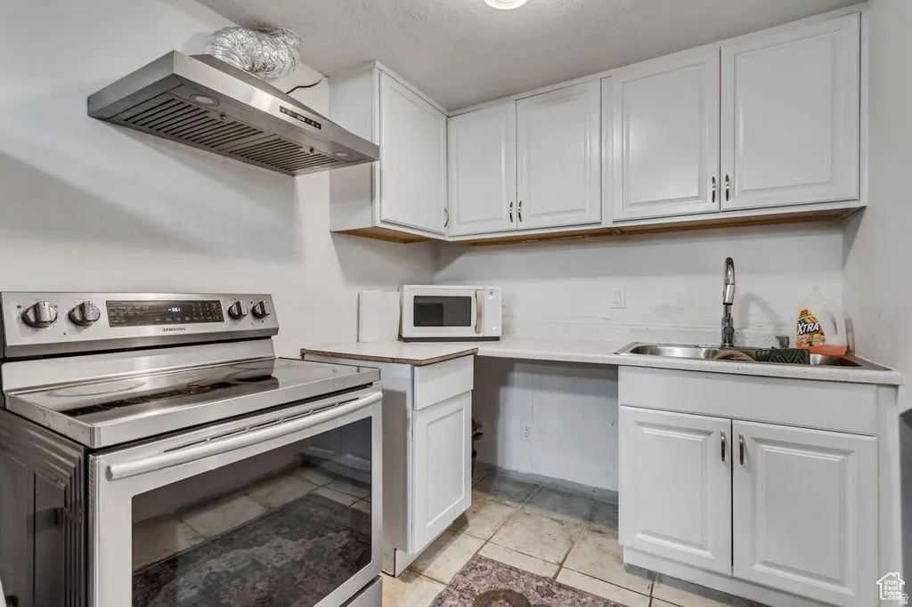Compact kitchen featuring white cabinetry and light countertops