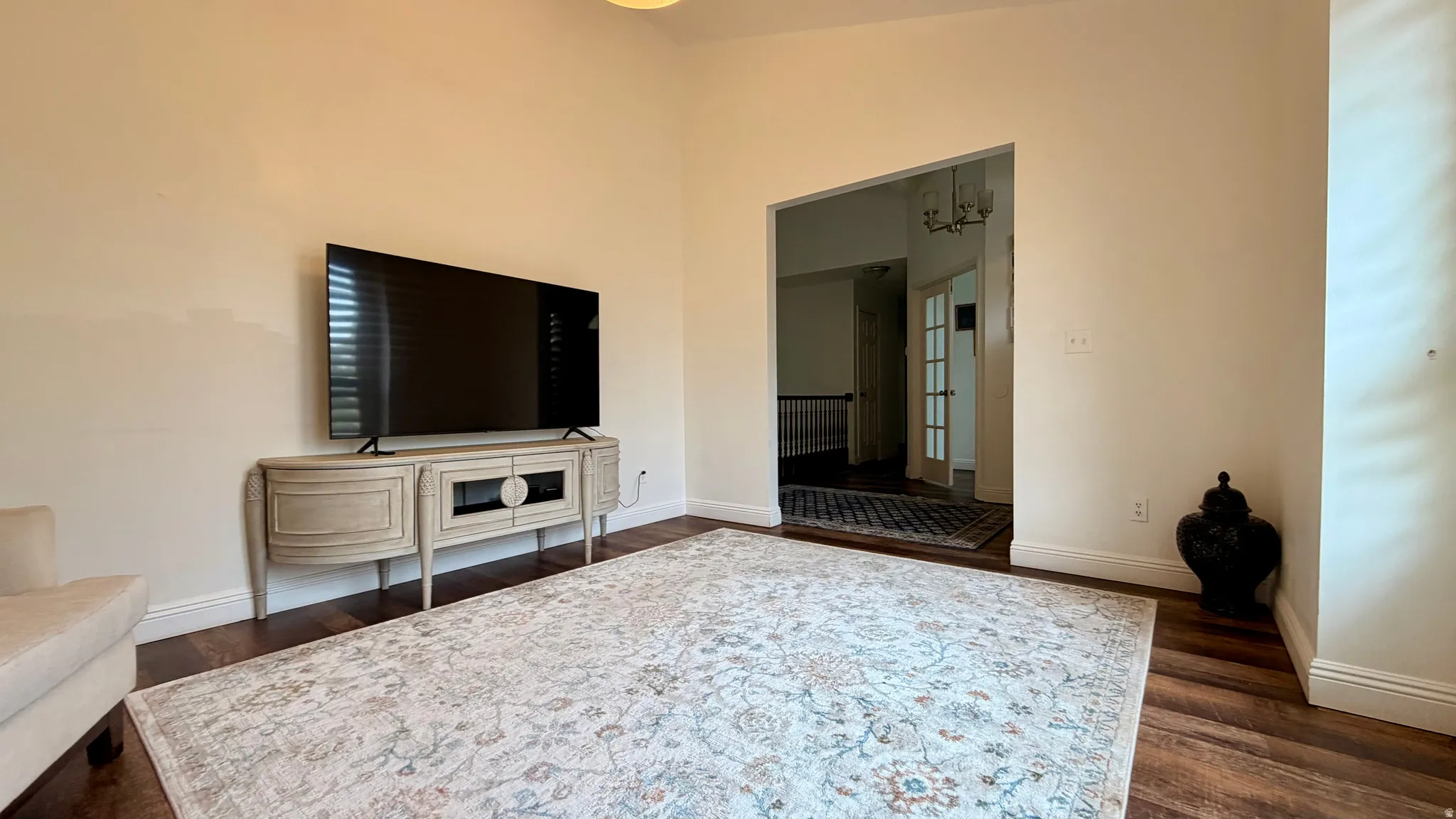 Spacious room featuring wood-finish flooring, a wide doorway, and light-toned walls