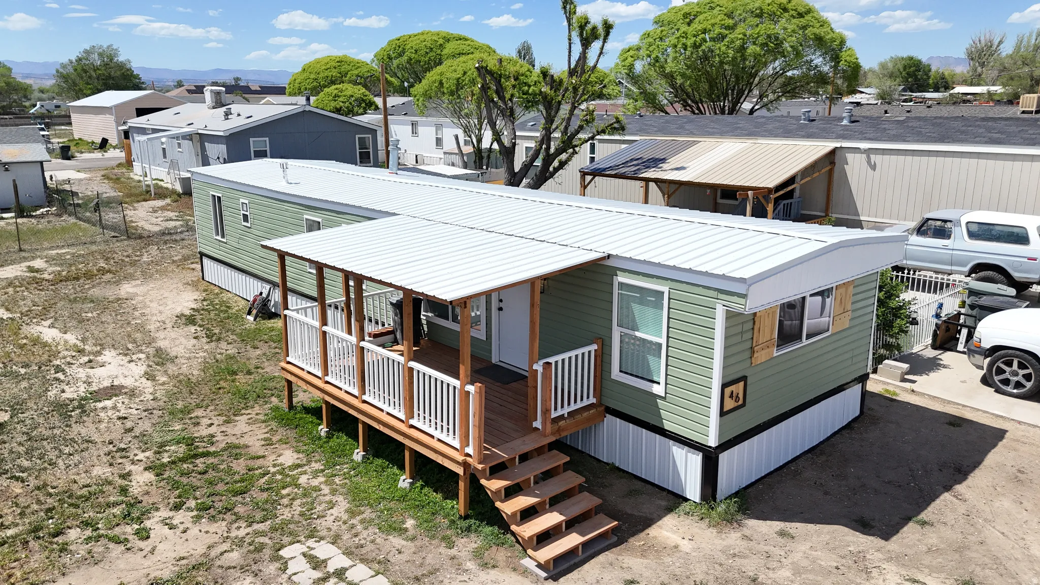 Light green siding exterior with a white metal roof