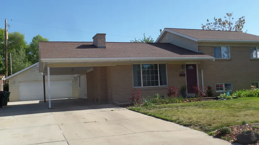 Front Yard of Traditional Brick Home with Carport and Extra Wide Detached 2-Car Garage