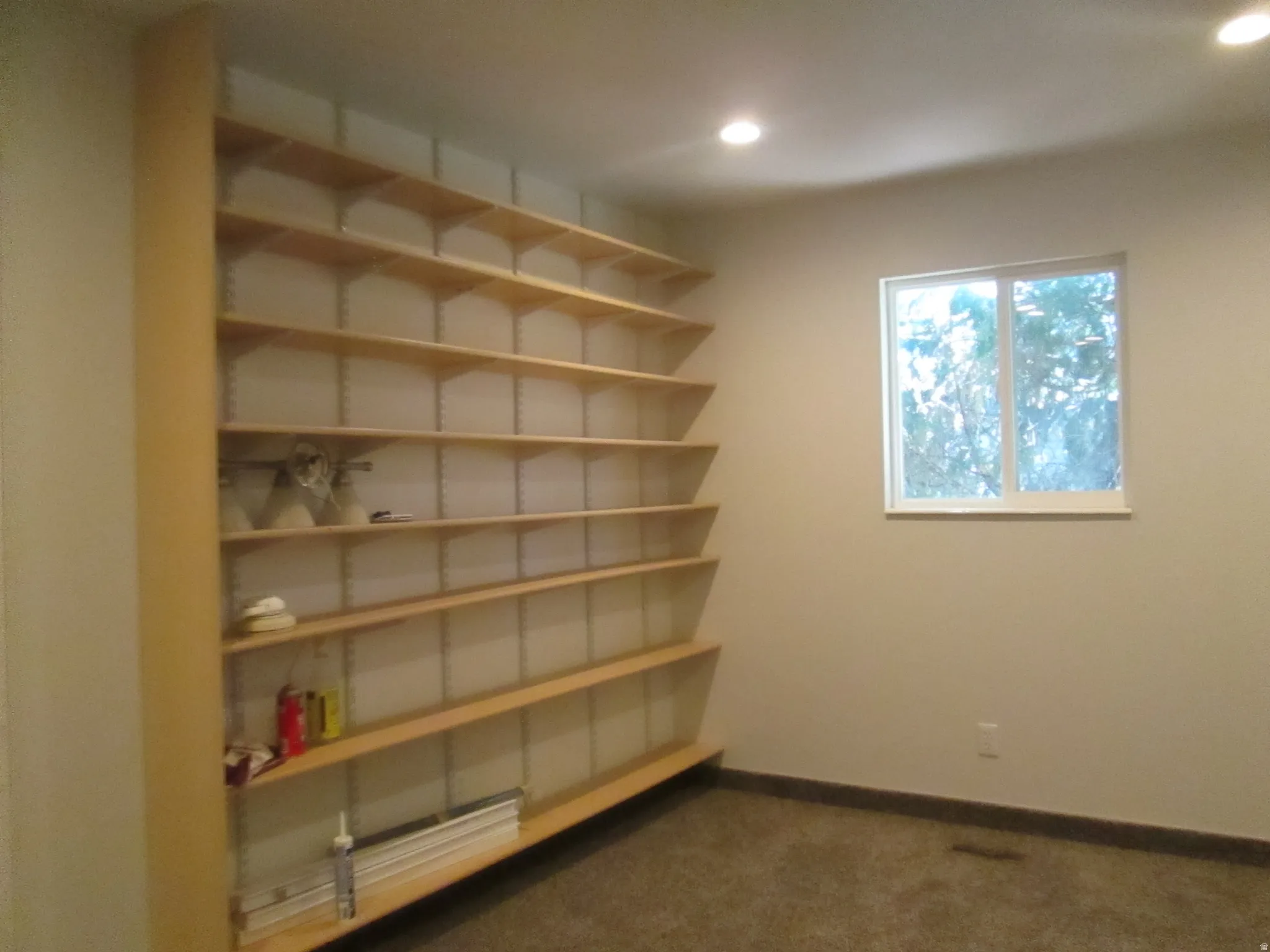 Extensive wall-mounted shelving unit with light wood-finish shelves