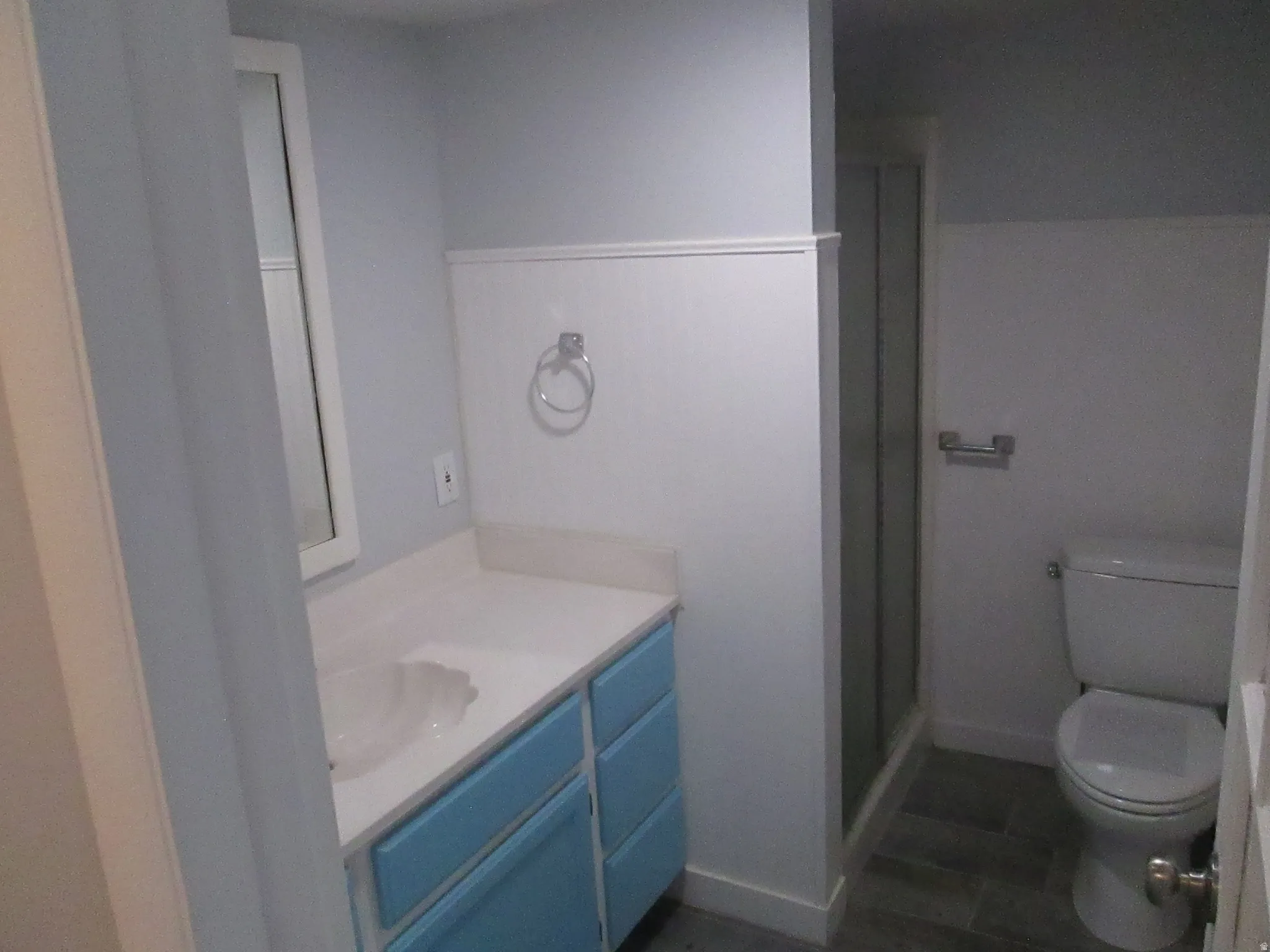 Bathroom vanity featuring a light-colored countertop, an undermount sink, and blue cabinet fronts