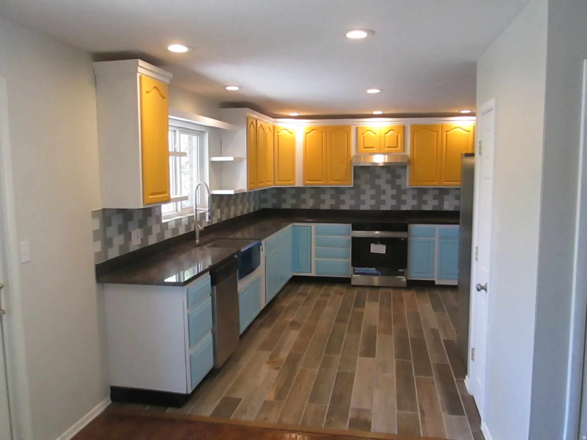 Kitchen featuring wood-finish flooring, recessed lighting, and a mosaic tile backsplash