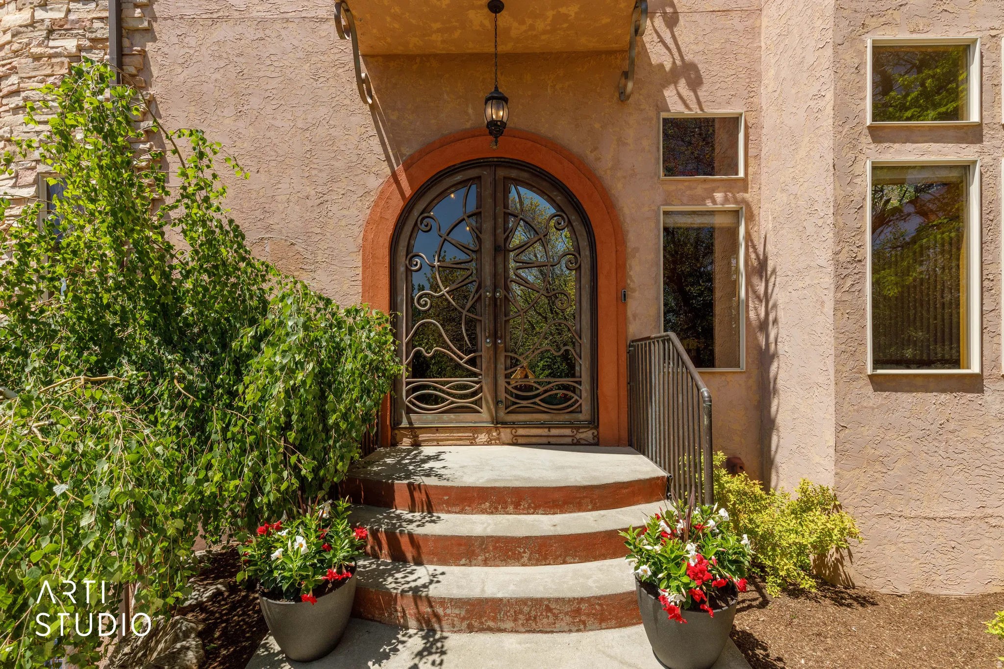 Arched double entry doors with decorative ironwork