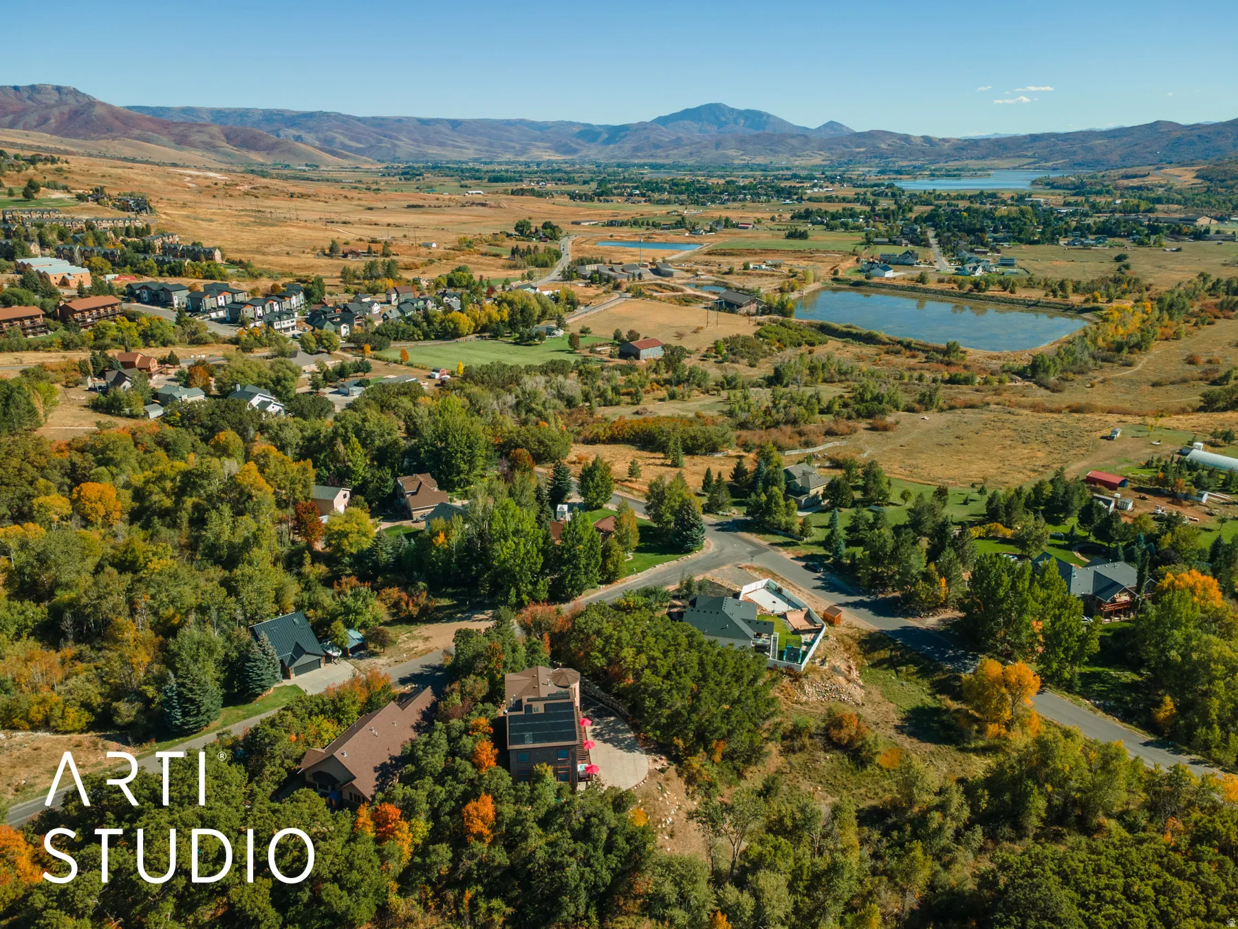 Aerial perspective showcasing a residential area with varied architecture, surrounded by extensive natural landscaping