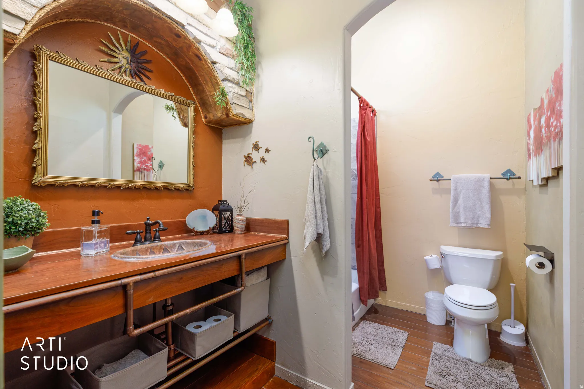 Bathroom featuring a vanity with a wood-finish countertop, an inset basin sink, and an ornate framed mirror