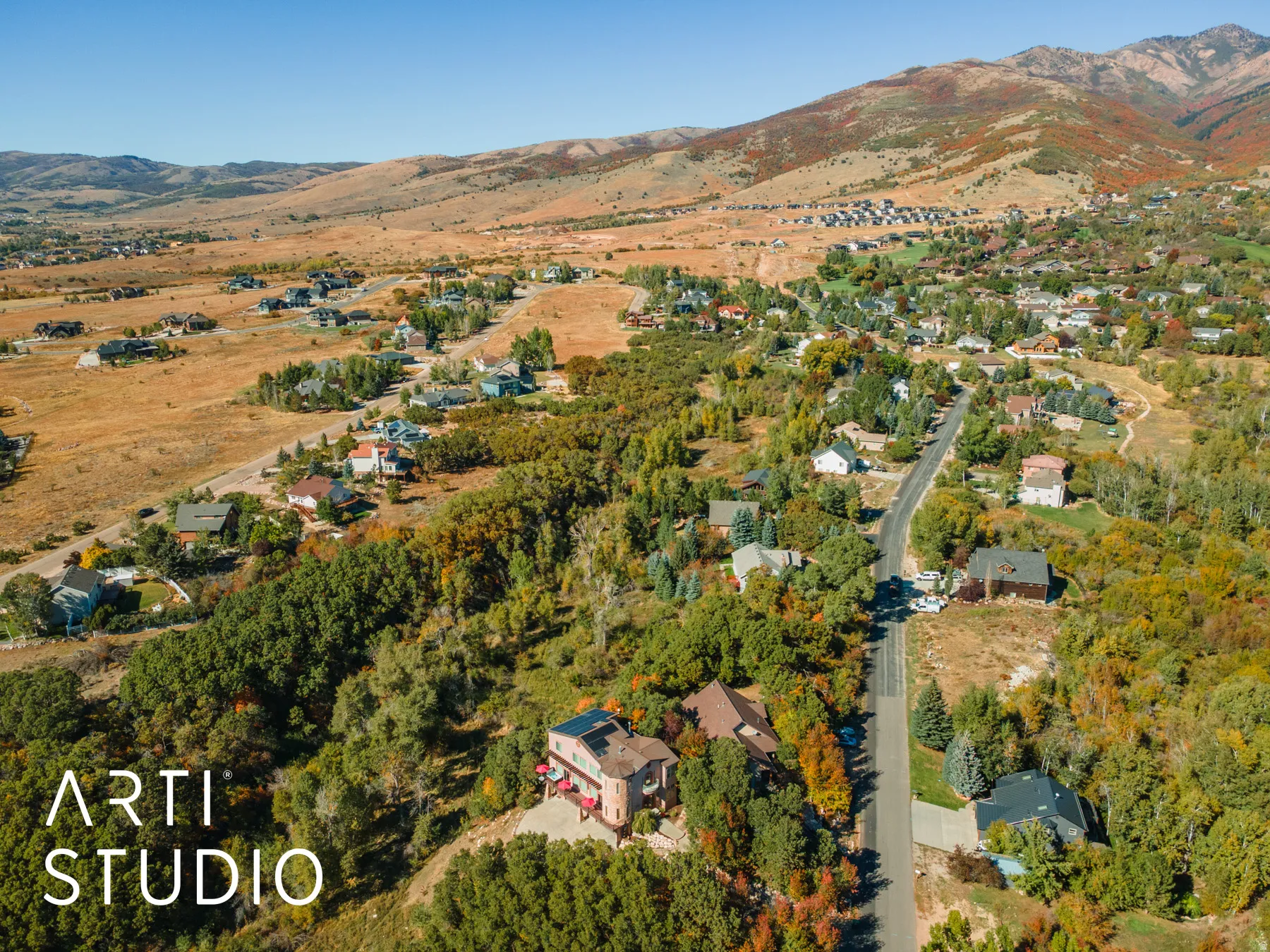 Aerial perspective showcasing a residential area with diverse properties and expansive natural surroundings