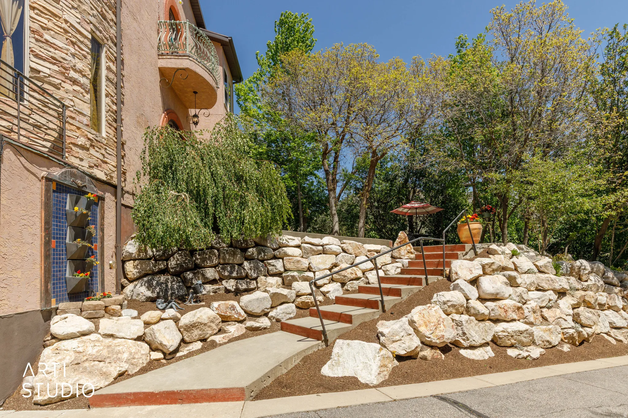 Terraced landscaping featuring natural stone retaining walls and mature trees