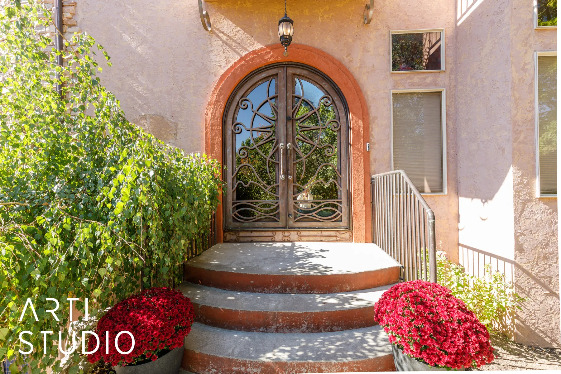 Arched entryway featuring ornate double doors with decorative wrought ironwork