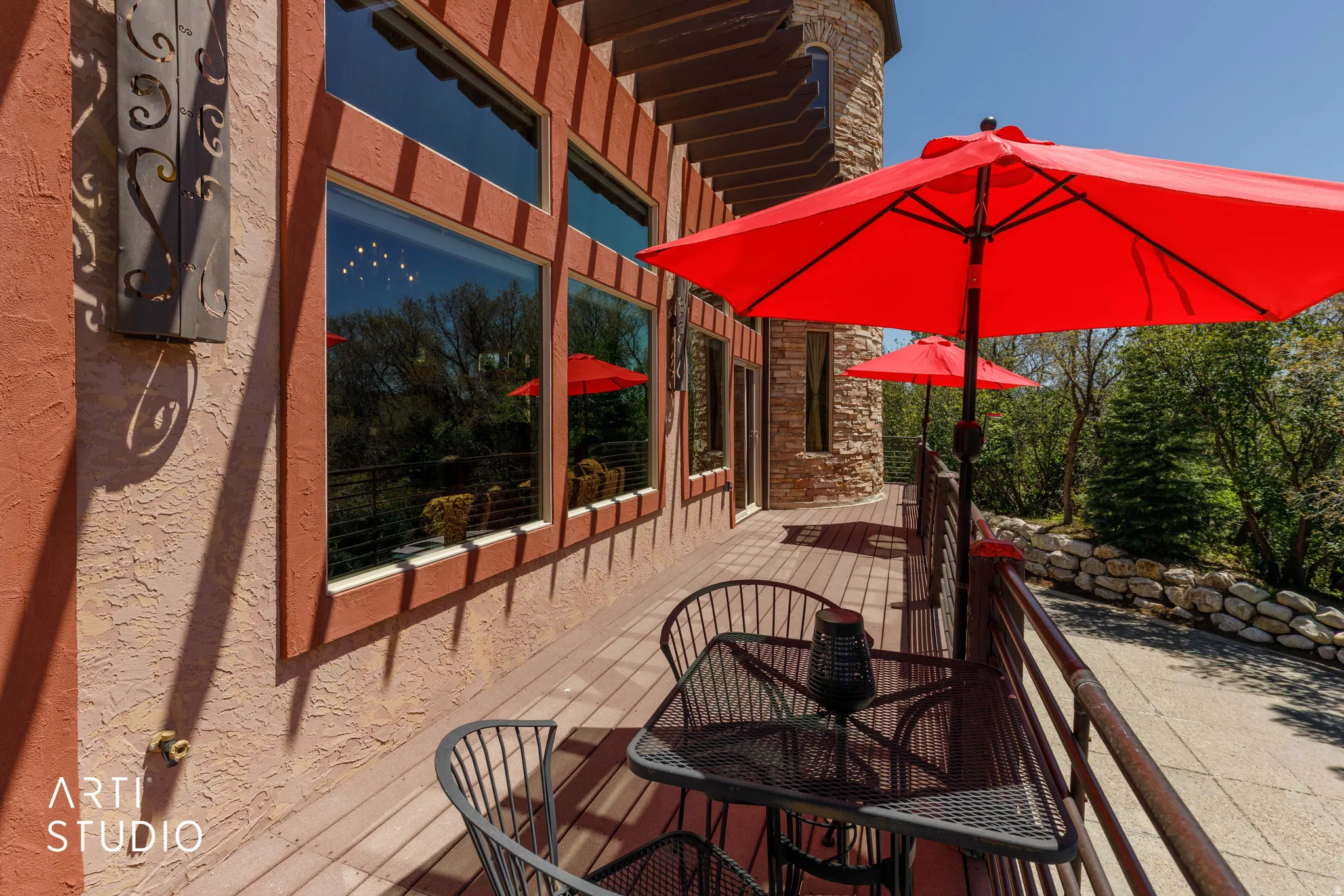 Expansive outdoor deck featuring wood-finish flooring and a decorative metal railing
