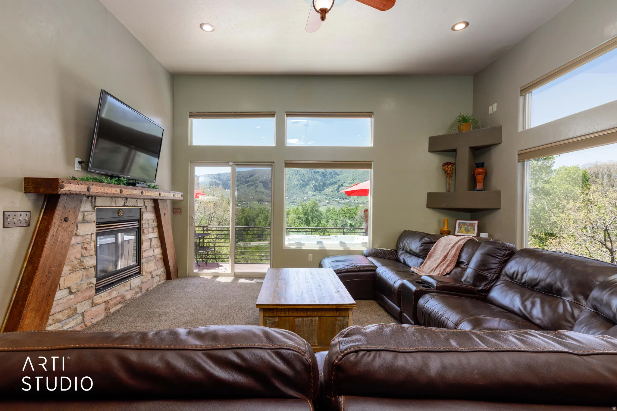 Living area featuring a stone-clad fireplace with a timber mantel, recessed lighting, and a ceiling fan