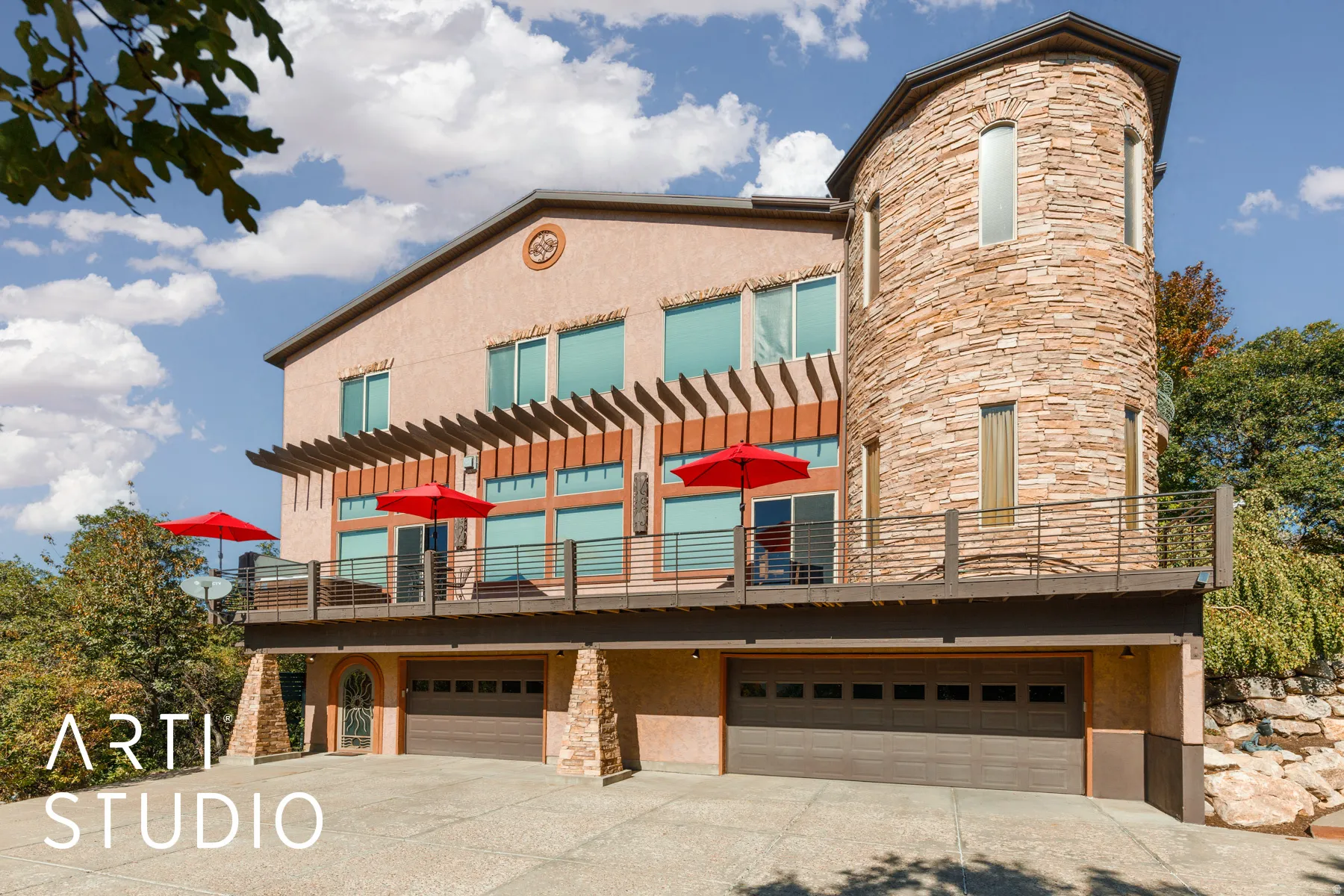 Multi-level stucco exterior with a prominent stone-clad turret