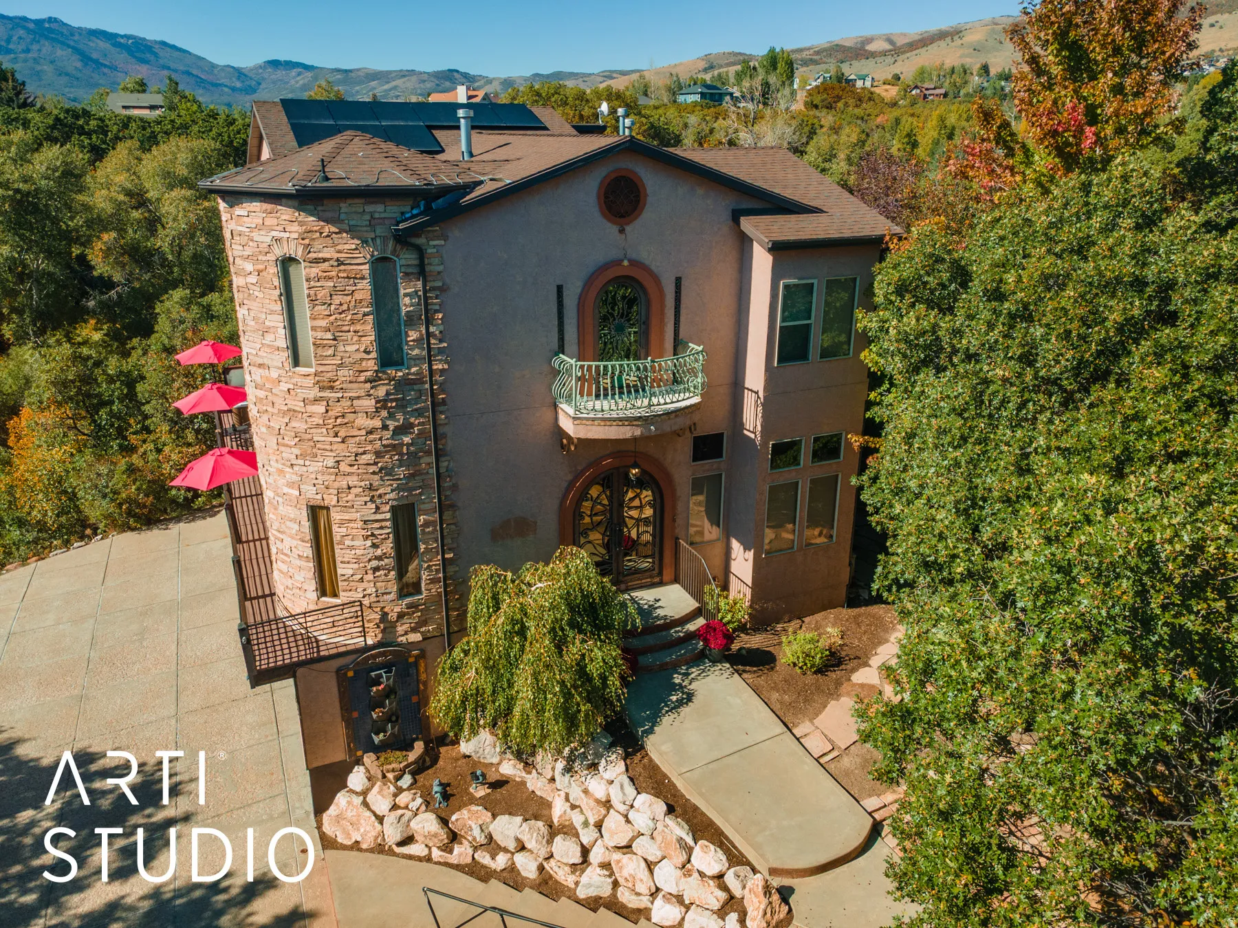 Stone-clad turret exterior featuring a stucco finish and solar panels