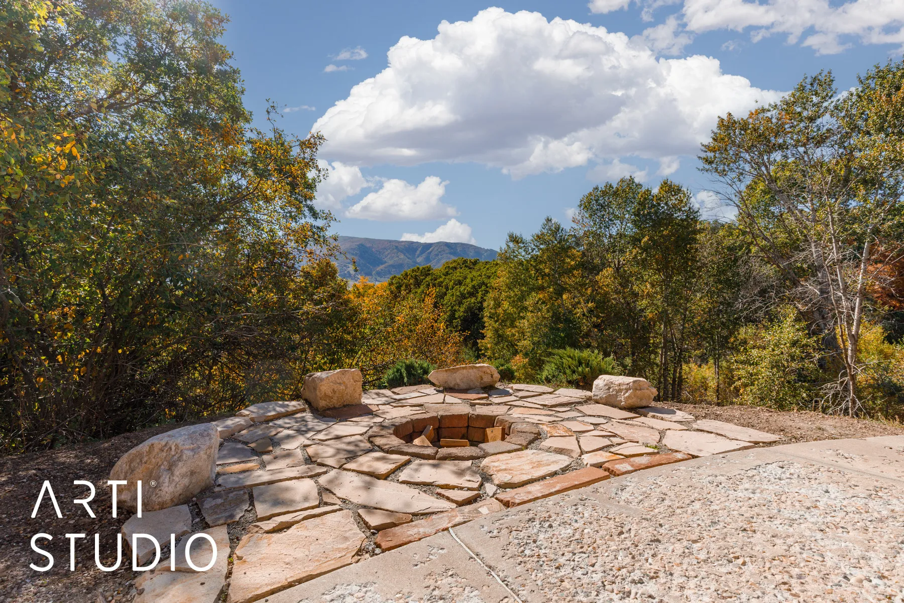Outdoor flagstone patio featuring a built-in fire pit with brick interior and stone surround