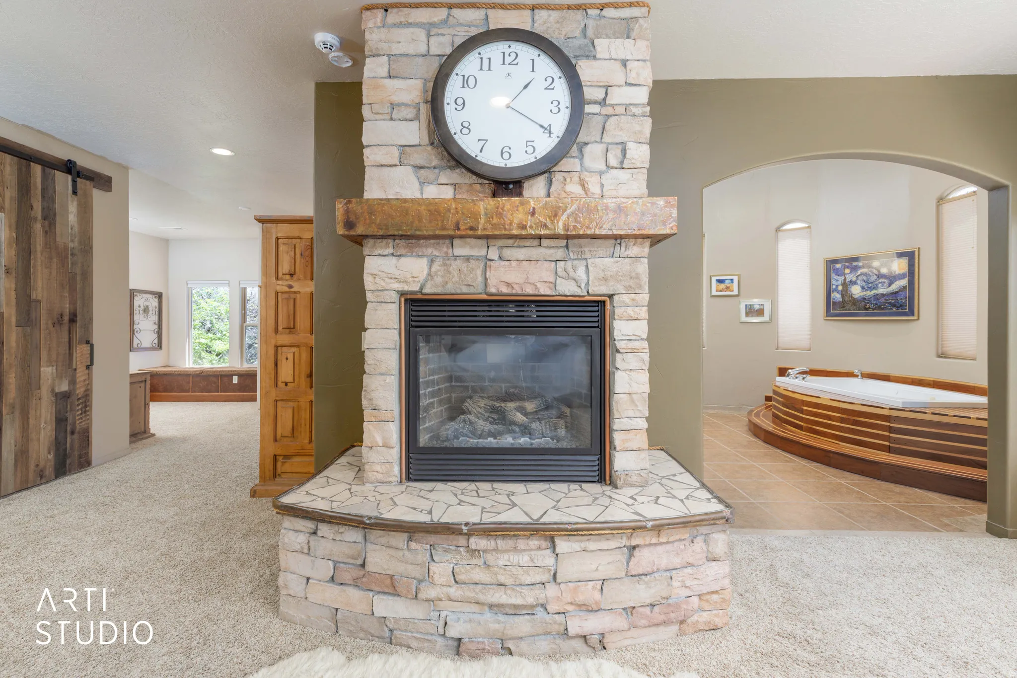 Stone-clad fireplace with a wood mantle and gas insert