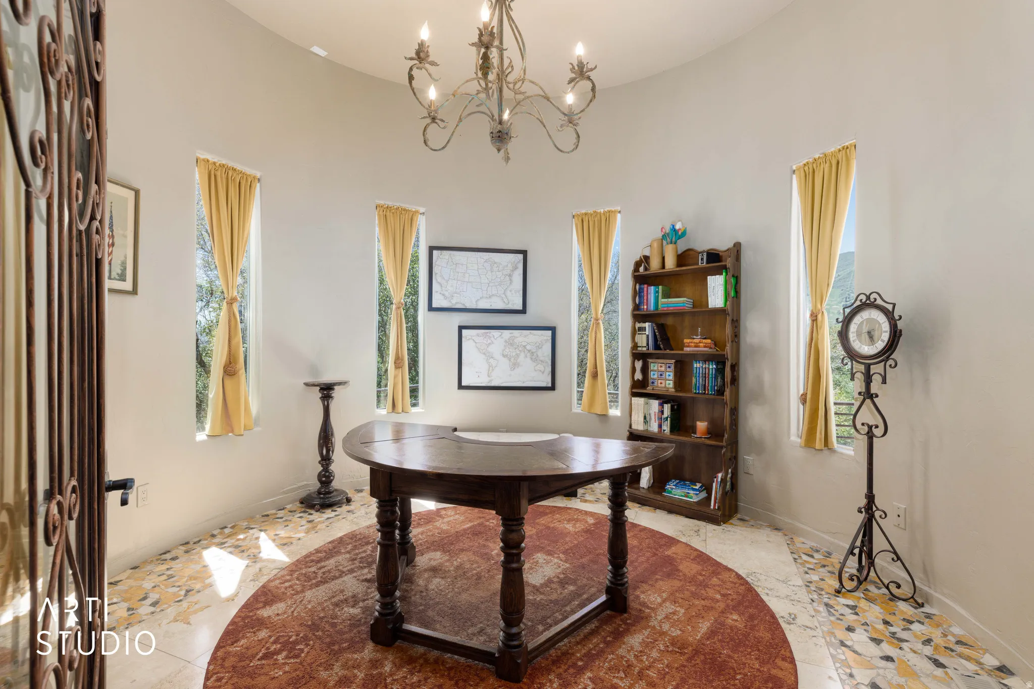 Rotunda space featuring a wrought iron chandelier and five tall arched windows