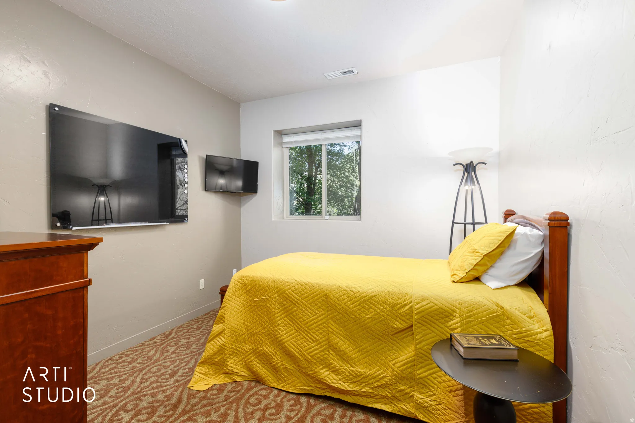 Windowed interior space with patterned carpeting, white and neutral-toned walls, and recessed lighting