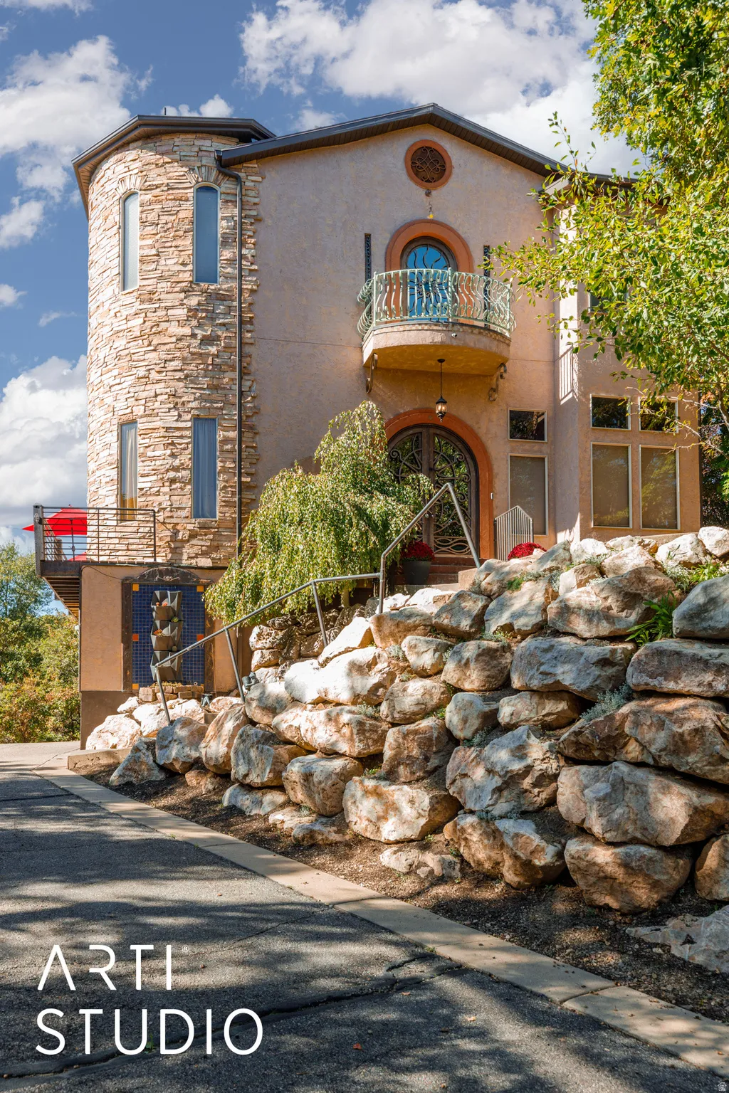 Distinctive stucco and stone exterior featuring a prominent stone turret