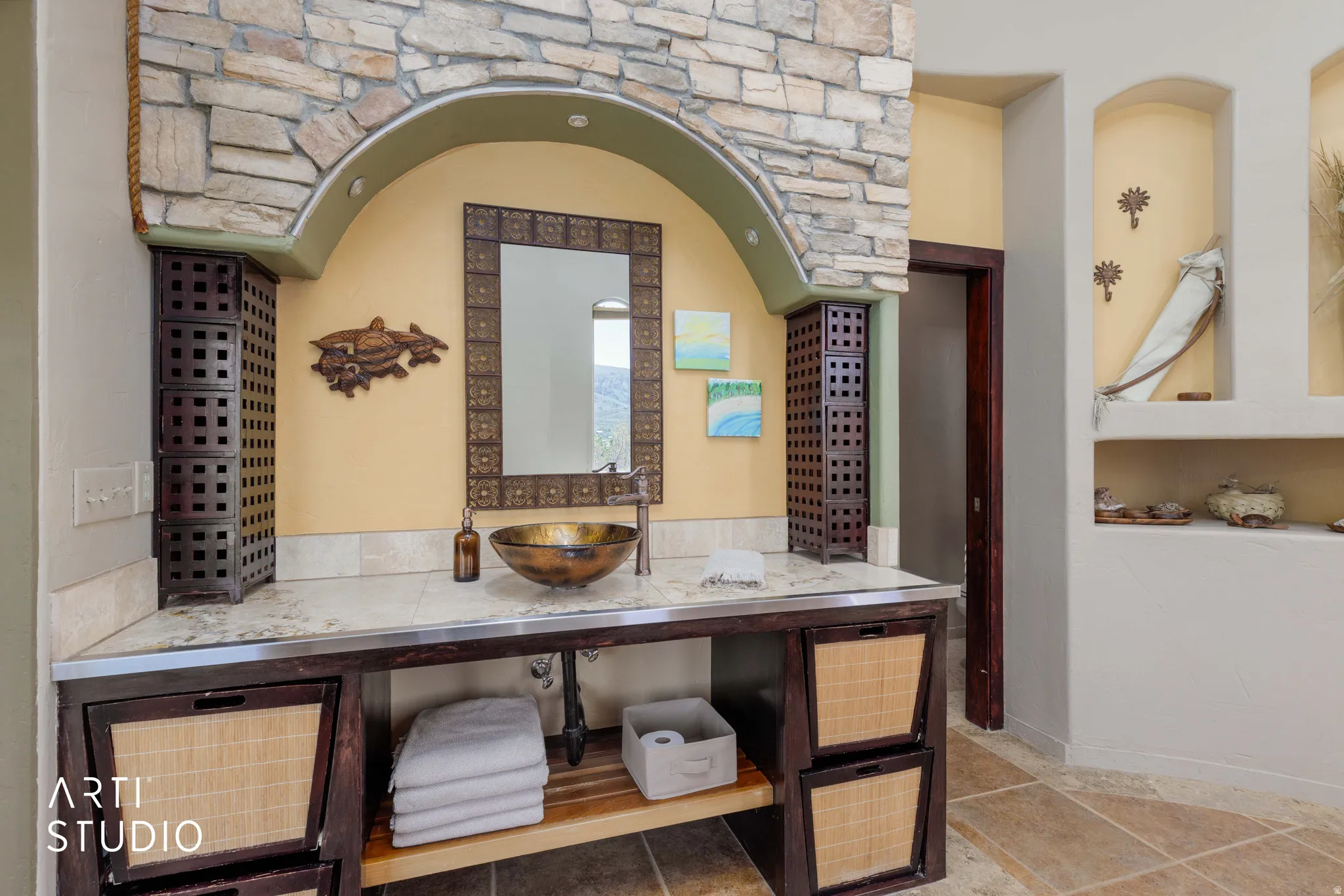 Bathroom vanity featuring an ornate mirror, vessel sink, and stone countertop