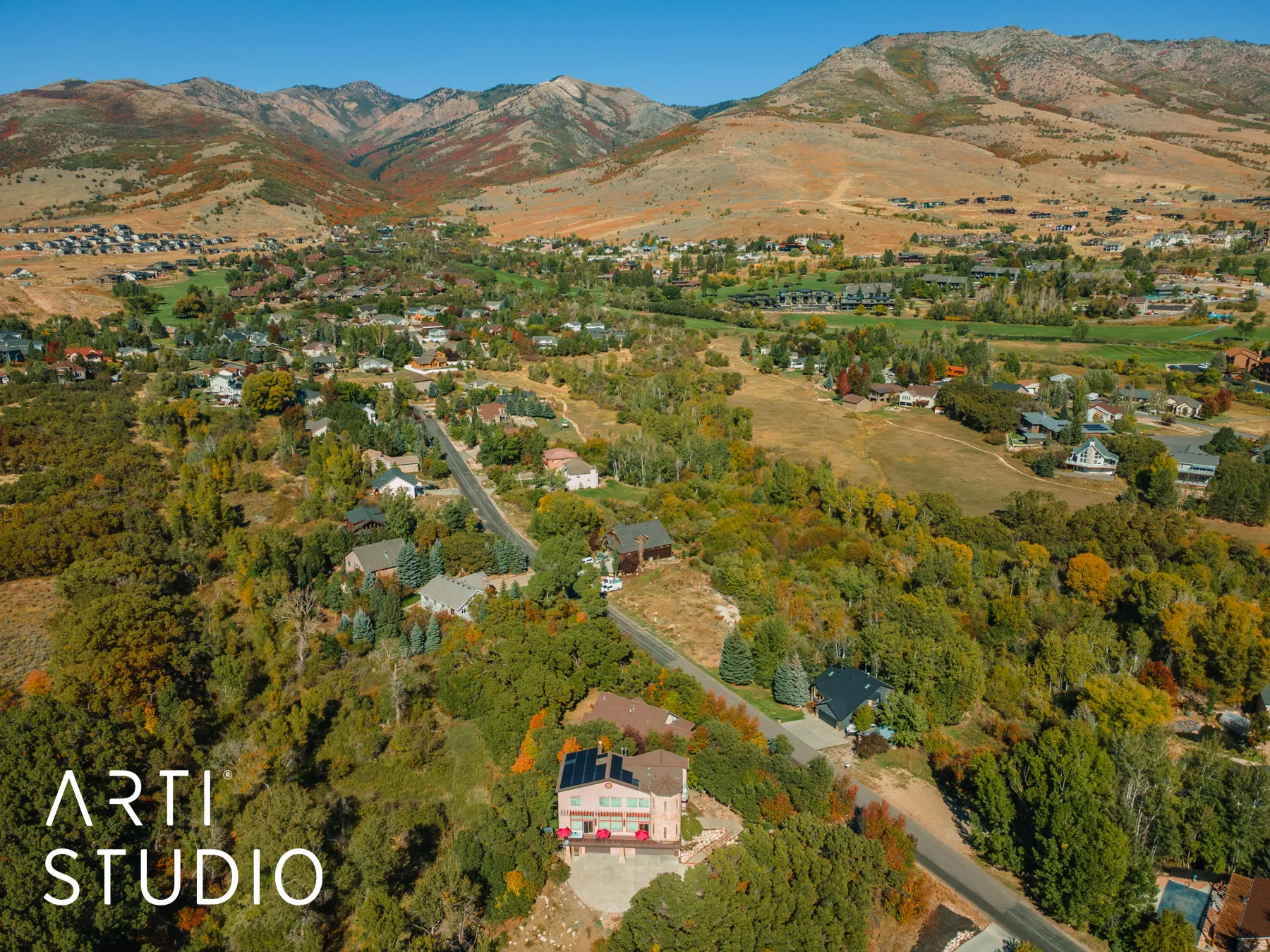 Expansive mountain landscape featuring a community of homes nestled among mature trees and natural terrain