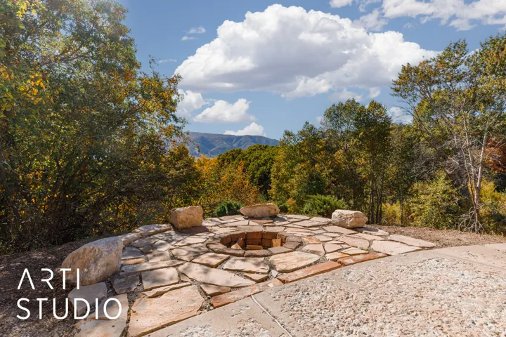 Outdoor flagstone patio featuring a built-in fire pit with brick interior and stone surround