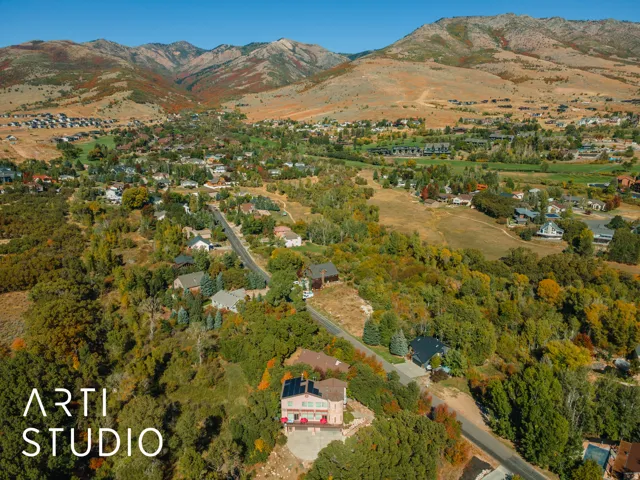 Expansive mountain landscape featuring a community of homes nestled among mature trees and natural terrain