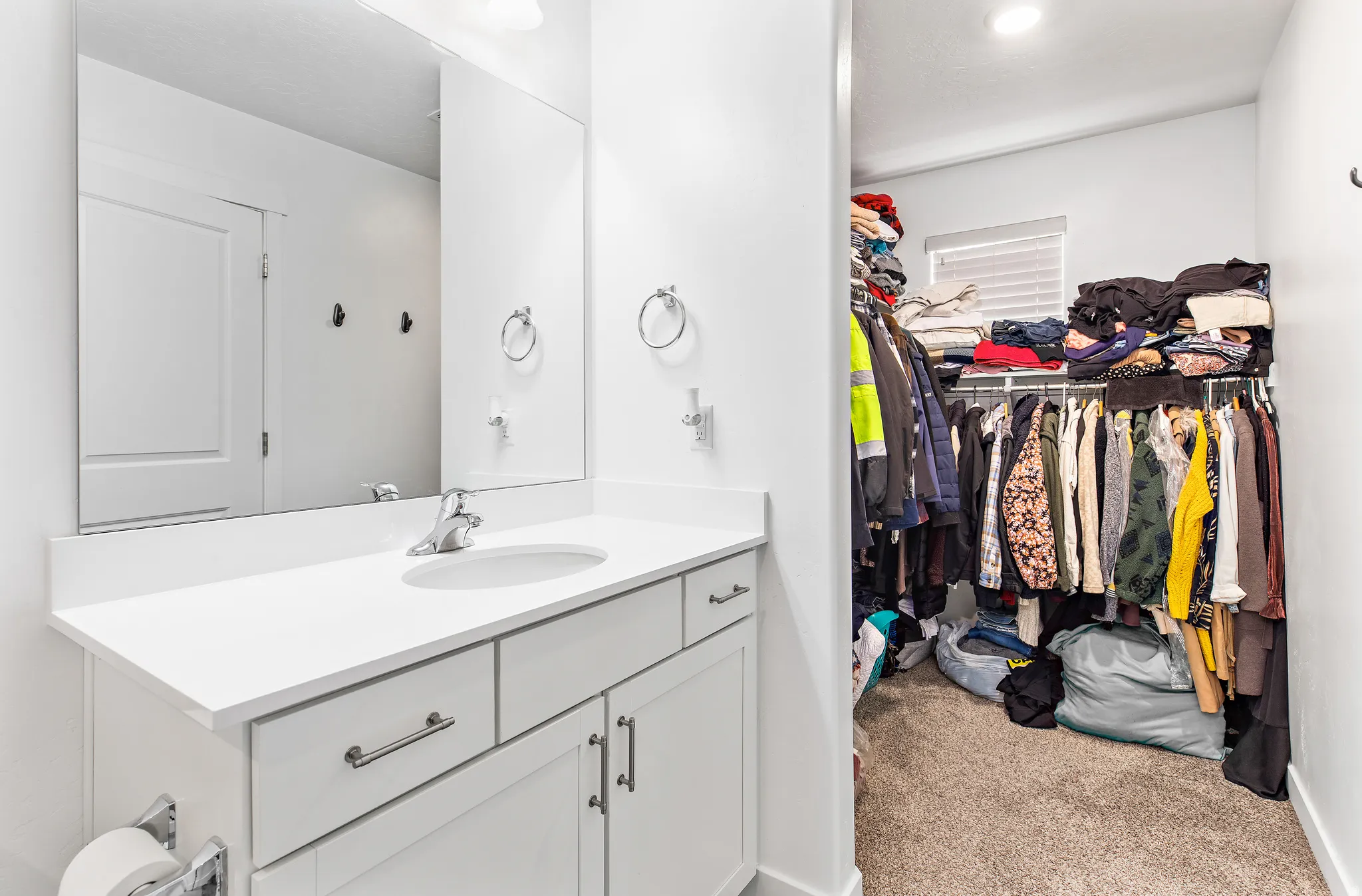 Bathroom vanity featuring a single basin sink, white countertop, and under-sink cabinetry