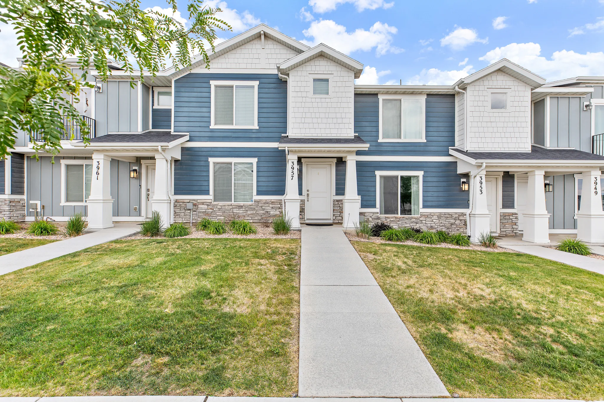 Contemporary townhome exterior featuring blue horizontal siding and white shake shingles