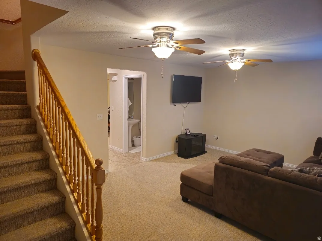 Staircase with light wood banister and carpeted steps