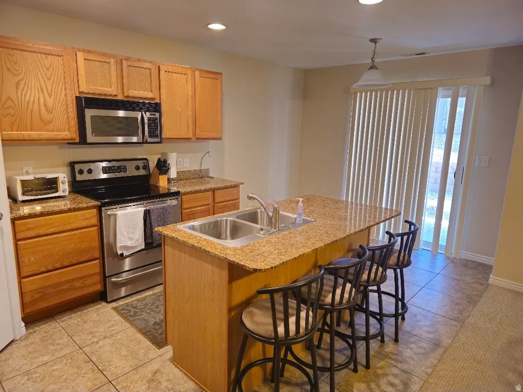 Kitchen featuring wood cabinetry, stainless steel appliances, and granite countertops