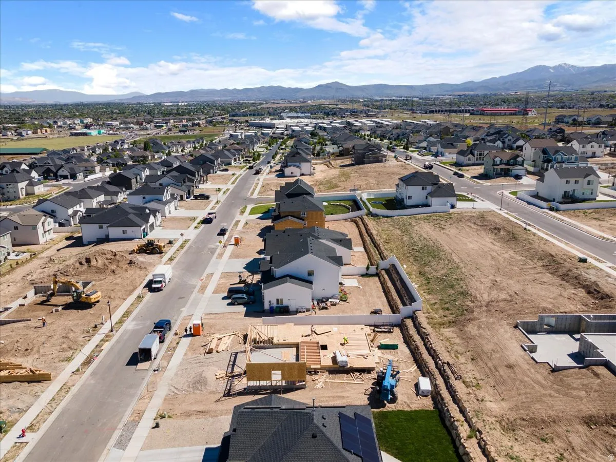 Expansive aerial perspective showcasing a developing residential area with modern homes and mountain scenery
