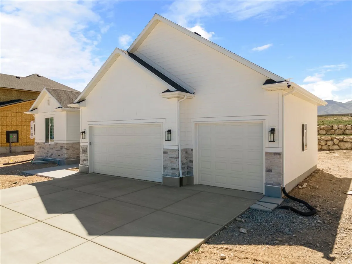 White exterior with stacked stone accents and a two-car garage