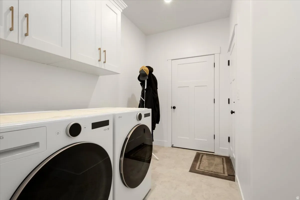 Laundry area featuring white shaker-style cabinetry with gold-tone hardware, a light-toned countertop, and recessed ceiling lighting