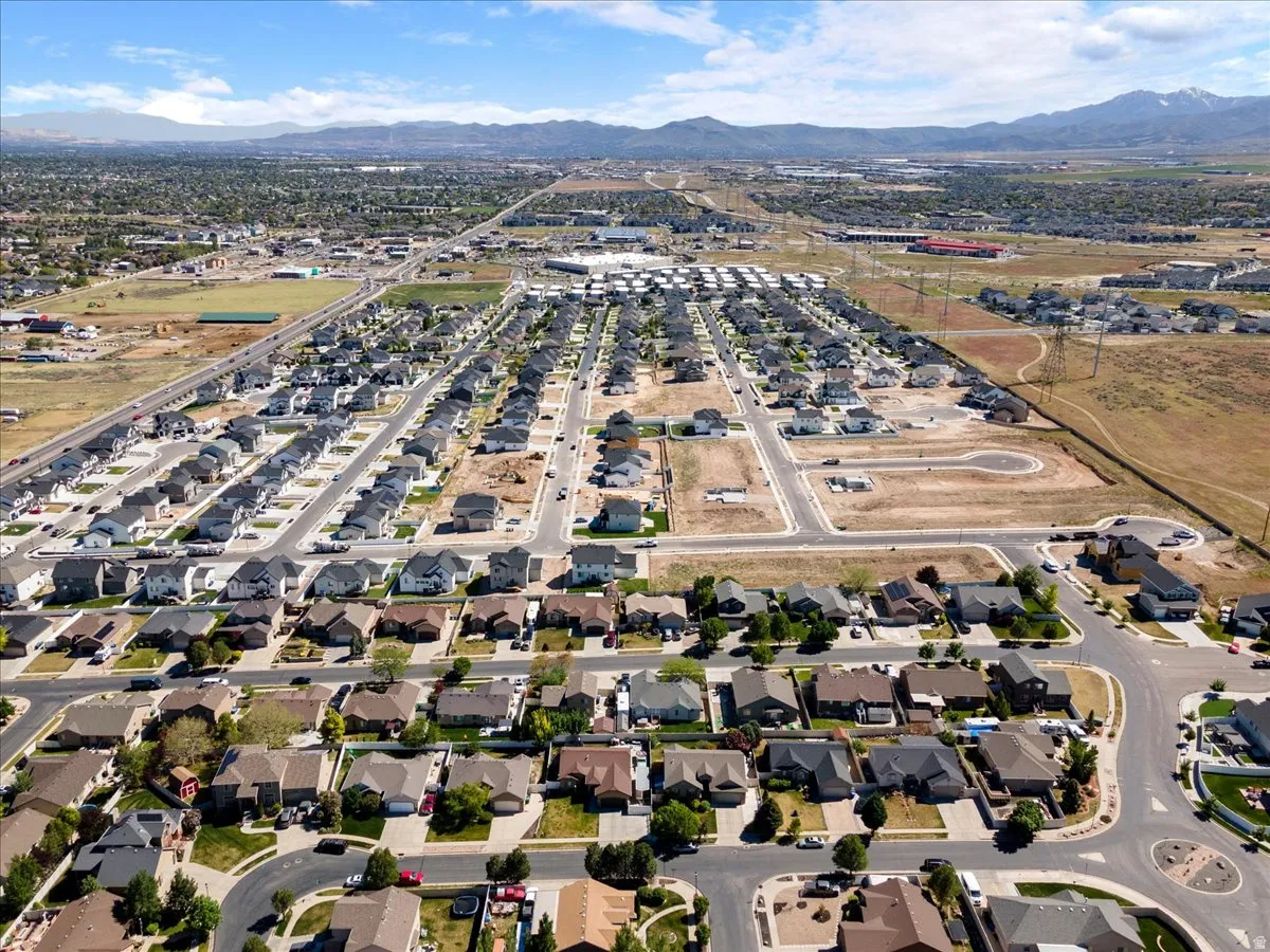 Expansive aerial view showcasing a developed residential neighborhood with established homes and new construction plots