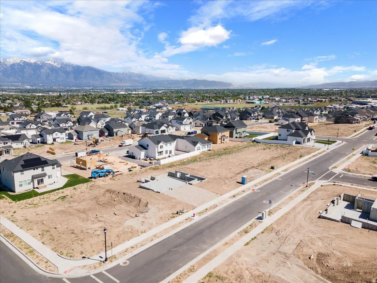 Developing residential area featuring a clear mountain backdrop, paved streets, and established sidewalks
