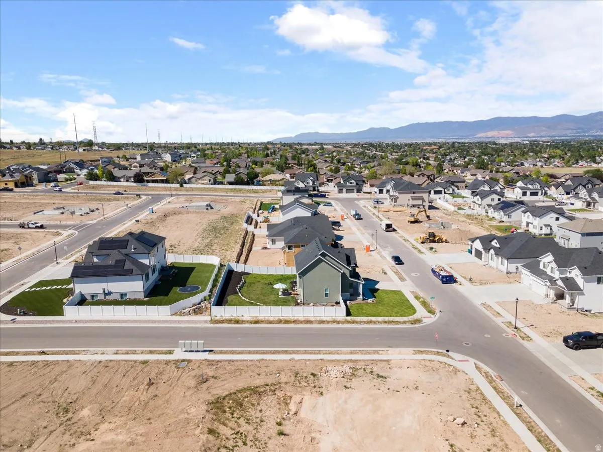 Aerial perspective of a developing residential community featuring newly constructed homes with dark-pitched roofs and light-colored siding