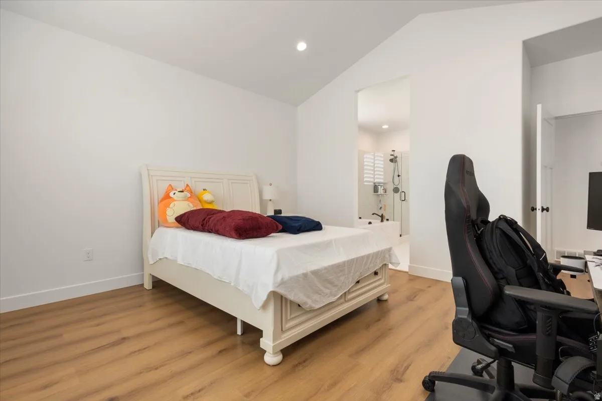 Vaulted ceilings enhance this space featuring wood-finish flooring and recessed lighting