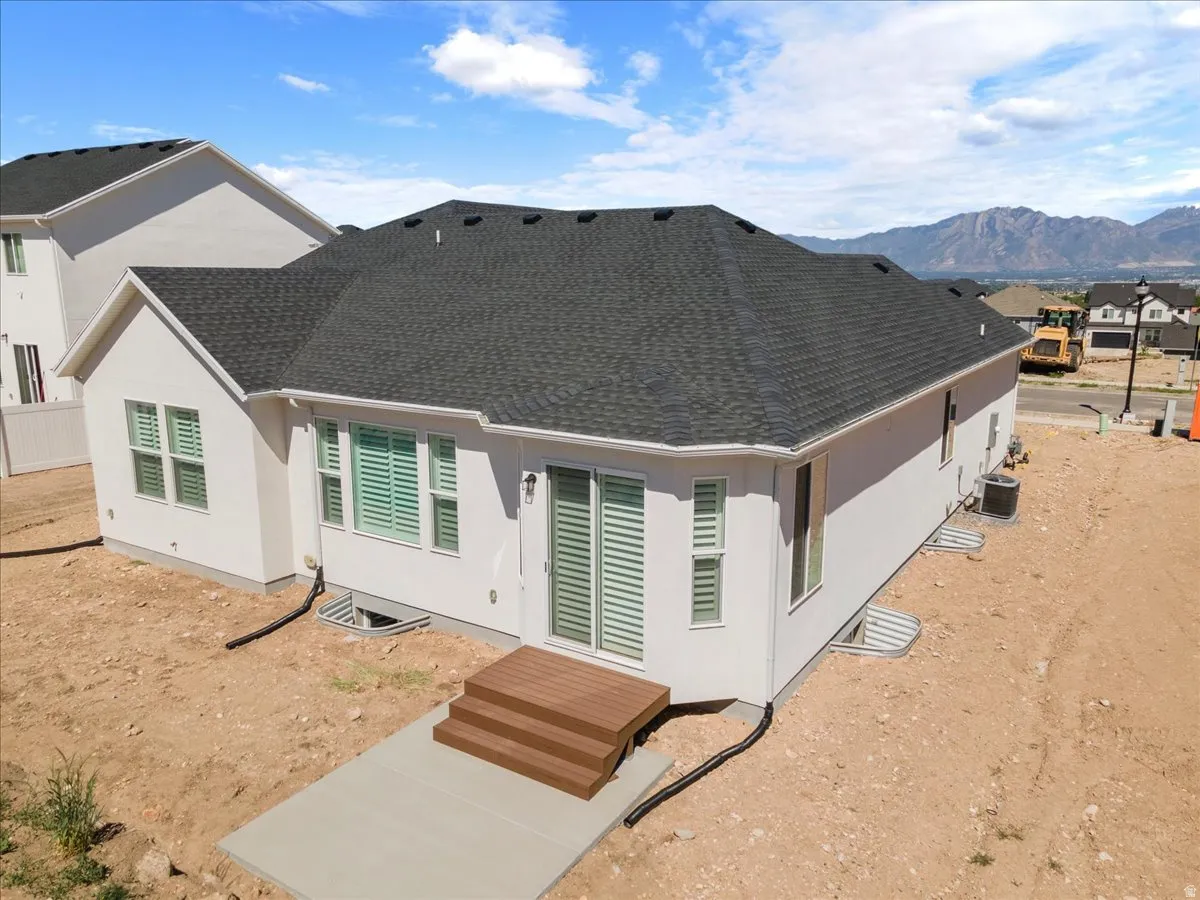Newly constructed property featuring a white exterior and a dark shingle roof