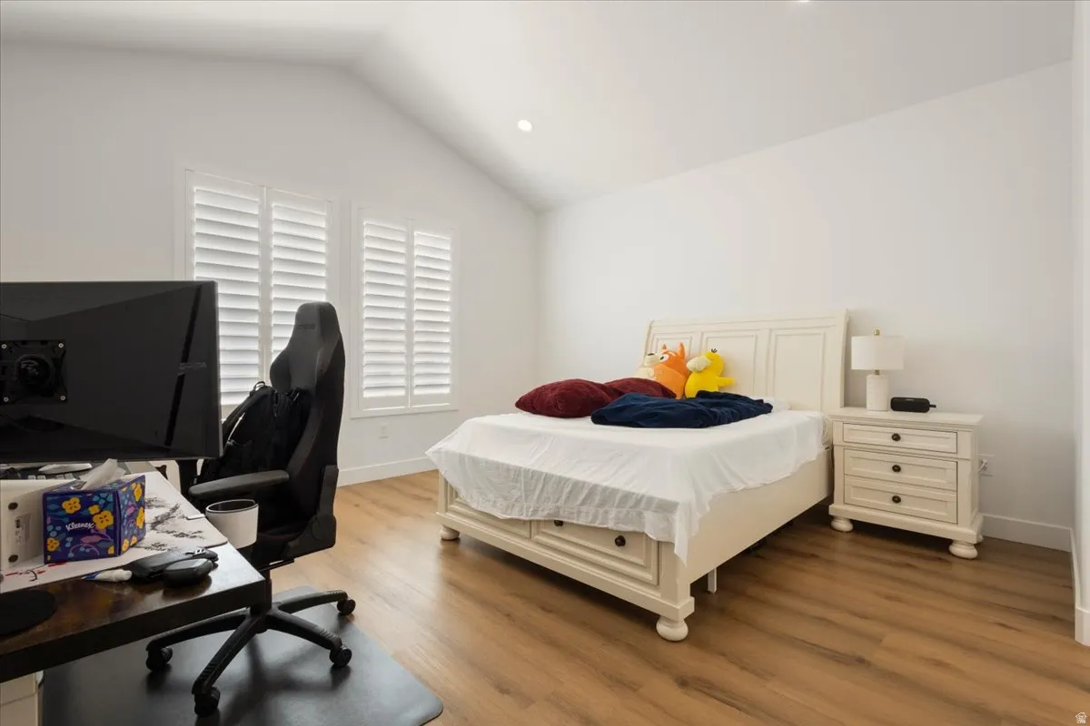 Spacious room with vaulted ceilings and wood-finish flooring