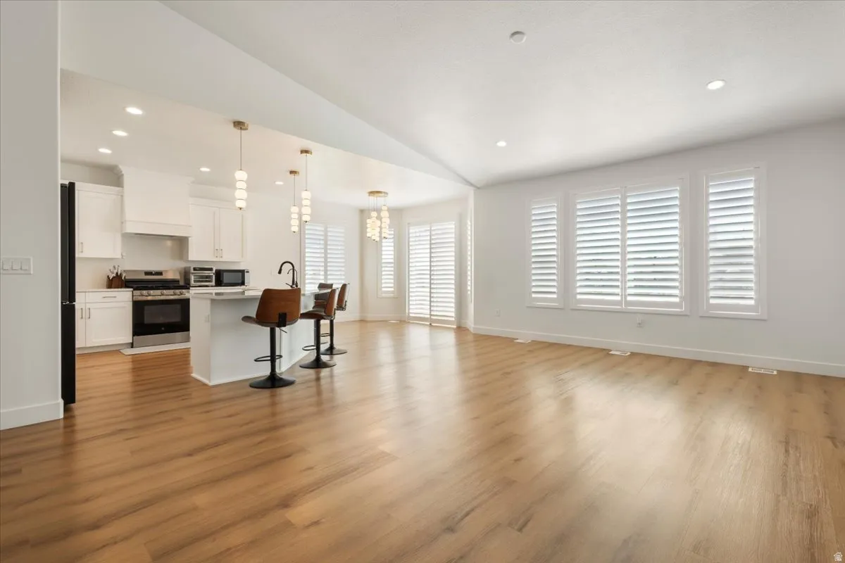Open-concept living area featuring wood-finish flooring and white walls