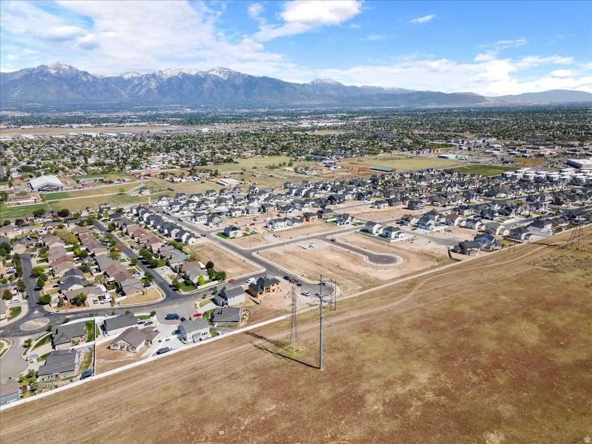 Expansive aerial perspective showcasing a developed residential area with numerous single-family homes and mountain backdrops