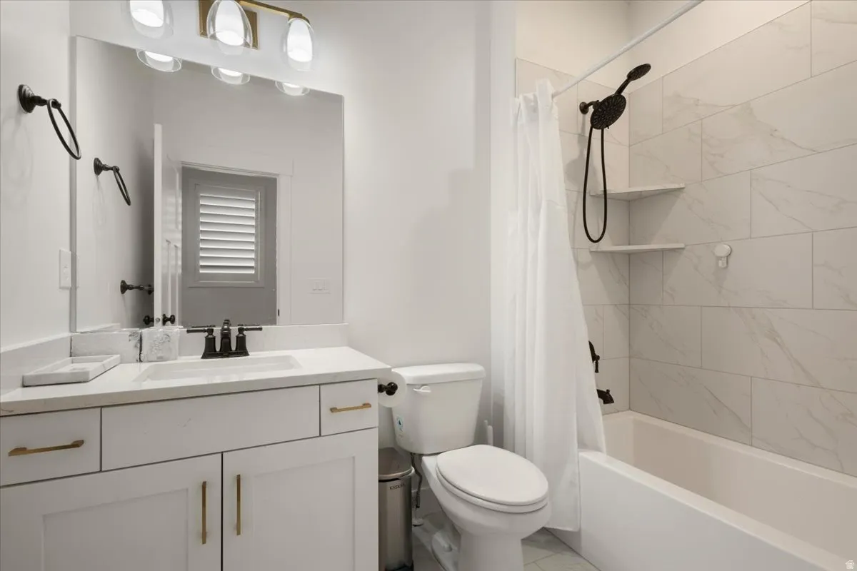 Contemporary bathroom featuring a white vanity with gold-tone hardware, a white countertop, and a rectangular undermount sink