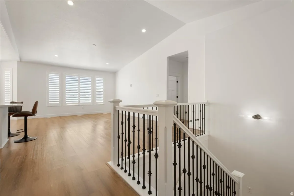 Interior staircase with white newel posts and black wrought iron balusters