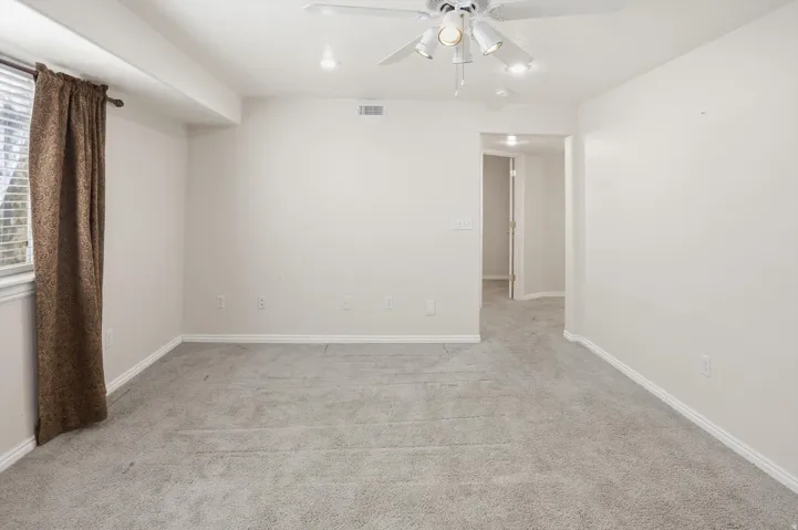 Carpeted room featuring a ceiling fan with integrated lighting, recessed lighting, and a window with blinds
