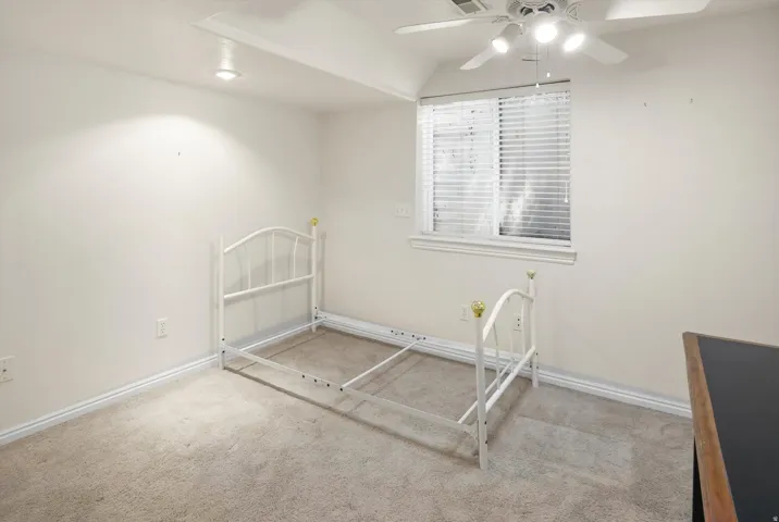 Room featuring neutral carpet flooring, white baseboards, and a window with blinds