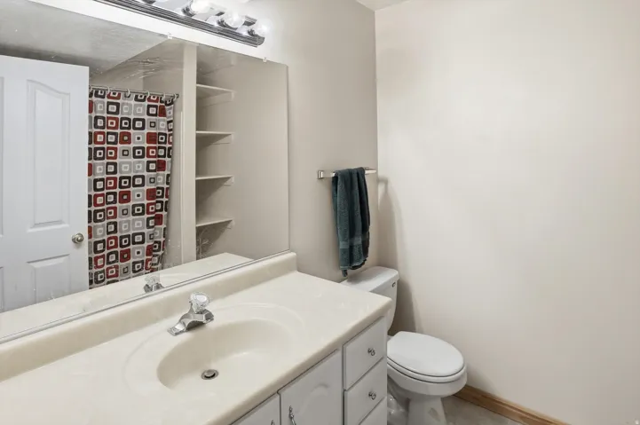 Bathroom vanity with an integrated sink, polished chrome faucet, and white cabinetry