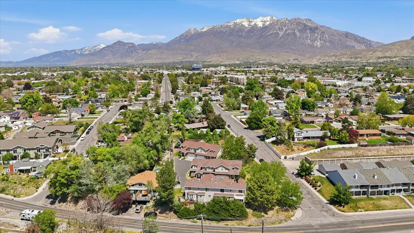 Expansive aerial perspective showcasing a residential area with a prominent mountain range backdrop