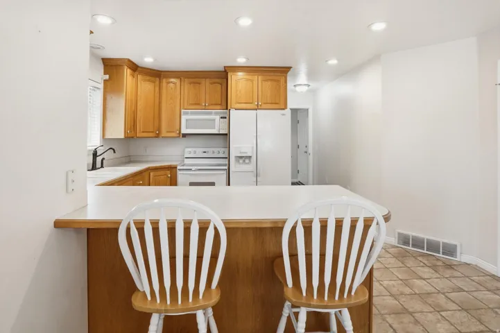 Kitchen featuring wood cabinetry, white countertops, and recessed lighting