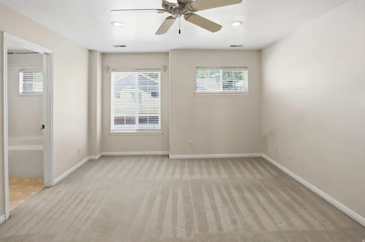 Carpeted interior space featuring neutral wall tones and white baseboards