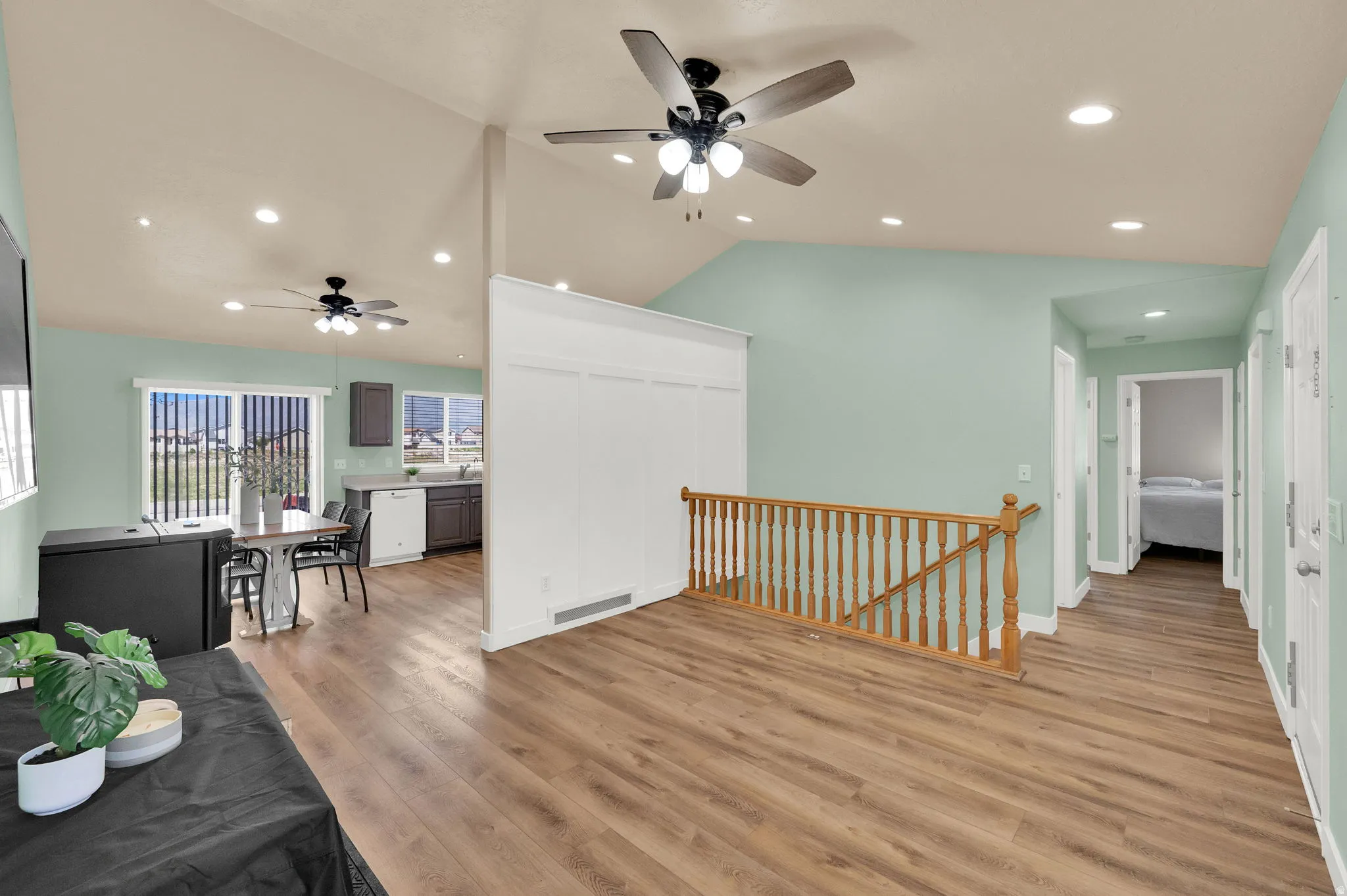 Spacious living area featuring wood-finish flooring, vaulted ceilings, and recessed lighting